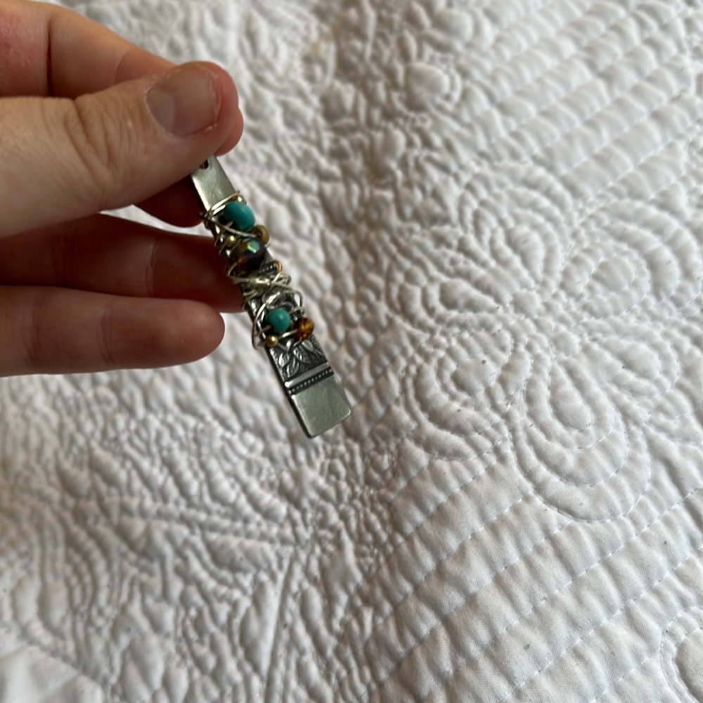 Spoon pendent with beading.